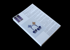 The photo shows a stack of A4-sized leaflets. The front page shows two photographs of Maja Behrmann's artistic work and on the right side of the page is a text set in a monospaced typeface.